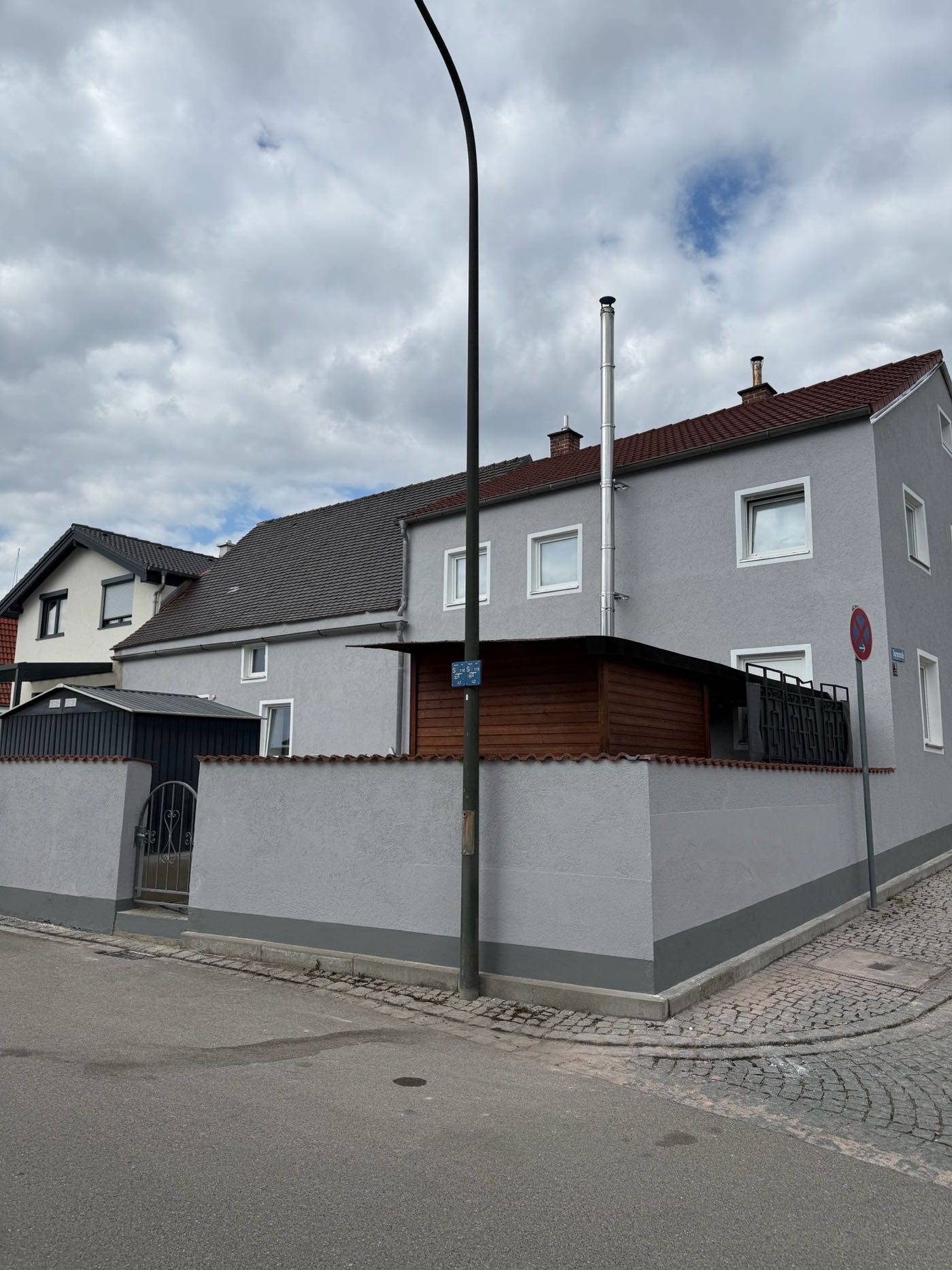 Altbaufassade nach dem Neuanstrich in Hellgrau mit weiß abgesetzten Fensterrahmen